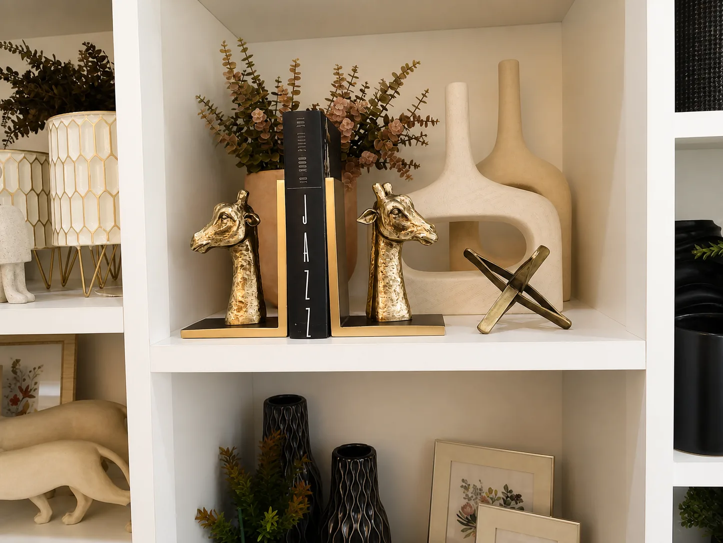 Aparador com girafas douradas, livros e vasos escultóricos na Bangalô