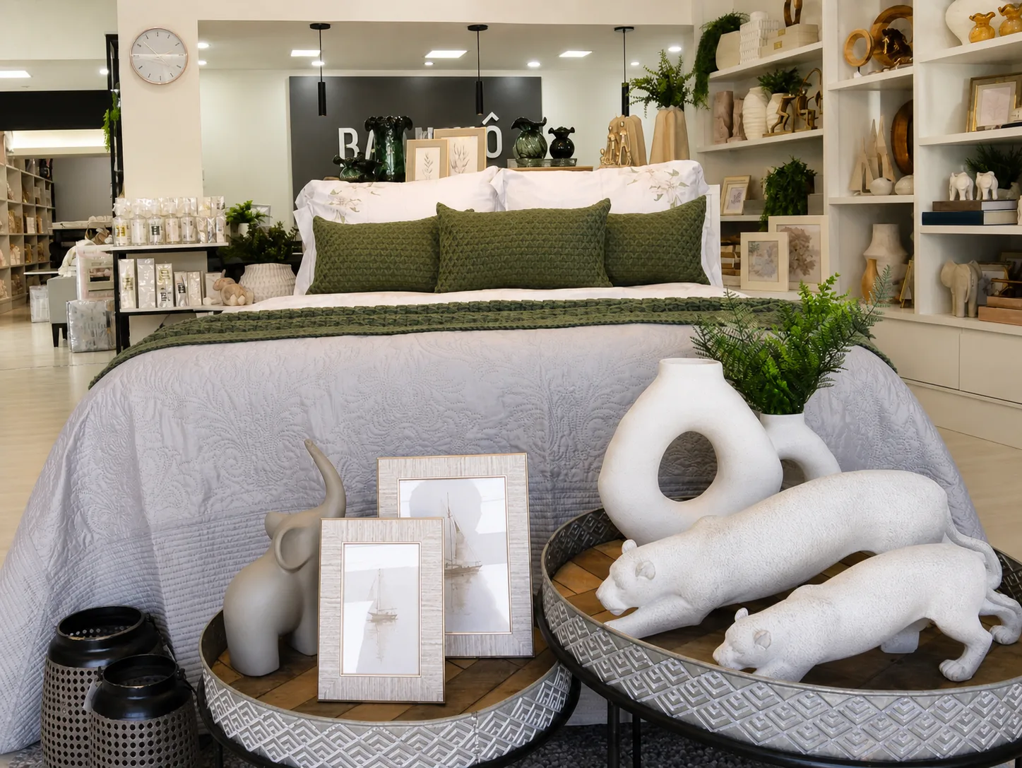 Cama montada com objetos decorativos e esculturas na loja Bangalô em Campinas